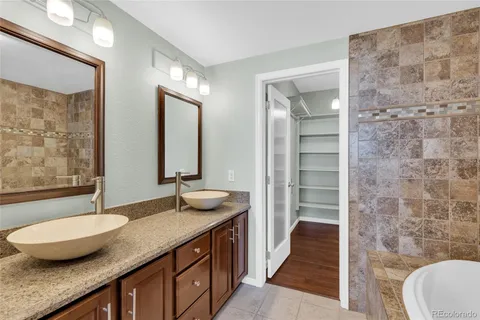 a bathroom with a granite countertop sink a toilet a mirror and shower