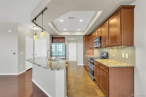 a large kitchen with stainless steel appliances granite countertop a sink and cabinets