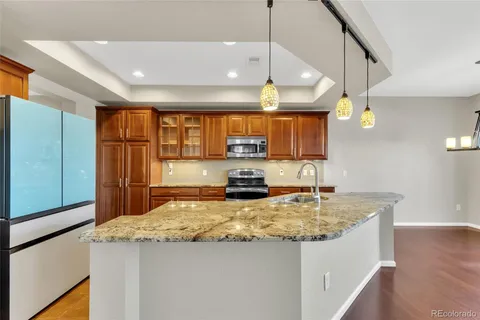 a kitchen with a sink a counter space appliances and cabinets