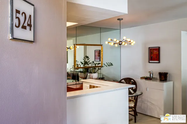 a dining room with chandelier and flower pot