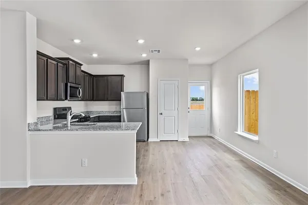 a kitchen with stainless steel appliances granite countertop a sink a stove a refrigerator and cabinets