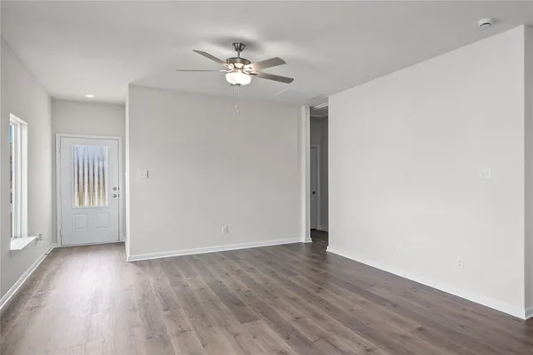 a view of an empty room with wooden floor