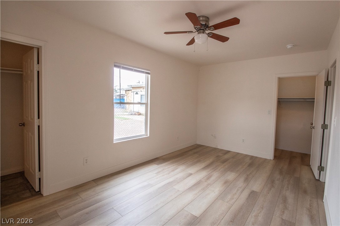 119 West Victory Road Henderson, NV 89015 - Photo 13 of 26 Laminate flooring and a ceiling fan create a comfortable atmosphere in this inviting bedroom.
