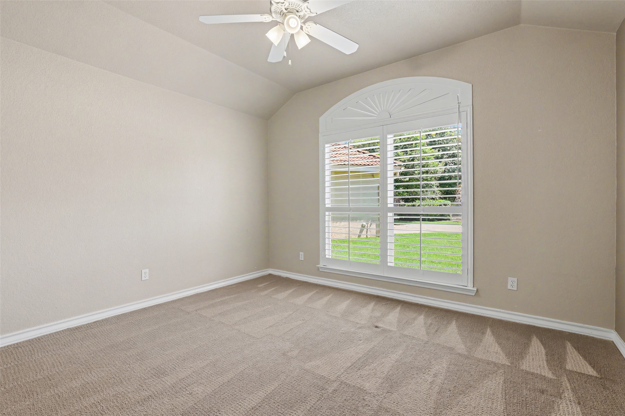 30107 Hamlet Circle Georgetown, TX 78628 - Photo 22 of 40 A quiet bedroom featuring vaulted ceilings and a large arched window with white plantation shutters.