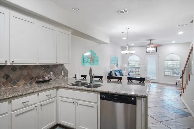 a kitchen with kitchen island granite countertop a sink a counter top space and cabinets