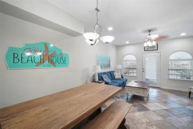 a living room with couch dining table and a chandelier