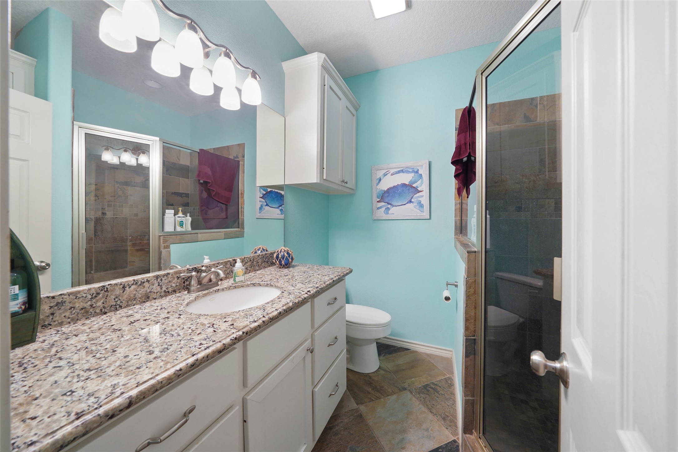 143 Boat Slip Road Matagorda, TX 77457 - Photo 17 of 31 a bathroom with a granite countertop sink a toilet and a mirror