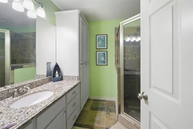 a bathroom with a granite countertop sink and a mirror
