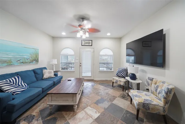 a living room with furniture a flat screen tv and kitchen view