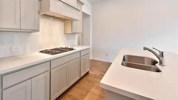a kitchen with granite countertop a sink a stove and cabinets
