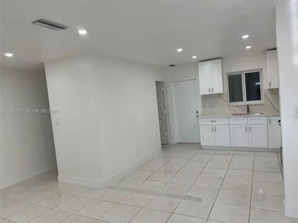 a view of a kitchen with white cabinets