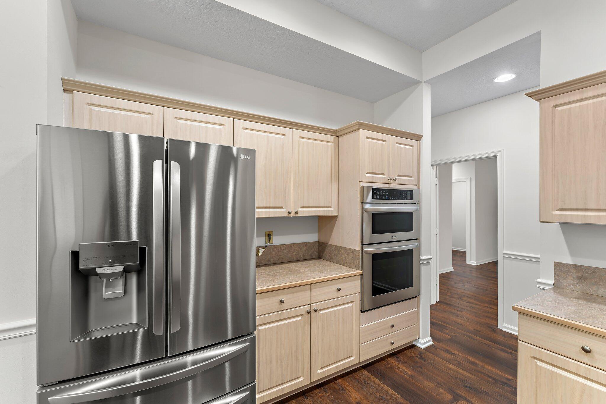 15784 Alexander Run Jupiter, FL 33478 - Photo 12 of 44 a kitchen with stainless steel appliances a refrigerator and wooden cabinets