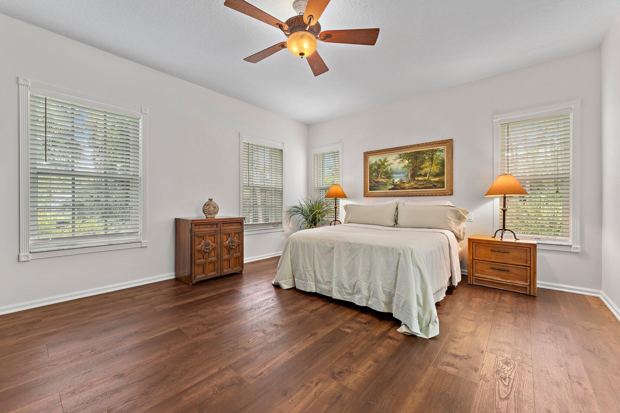 15784 Alexander Run Jupiter, FL 33478 - Photo 17 of 44 a spacious bedroom with a bed a dresser and next to a window