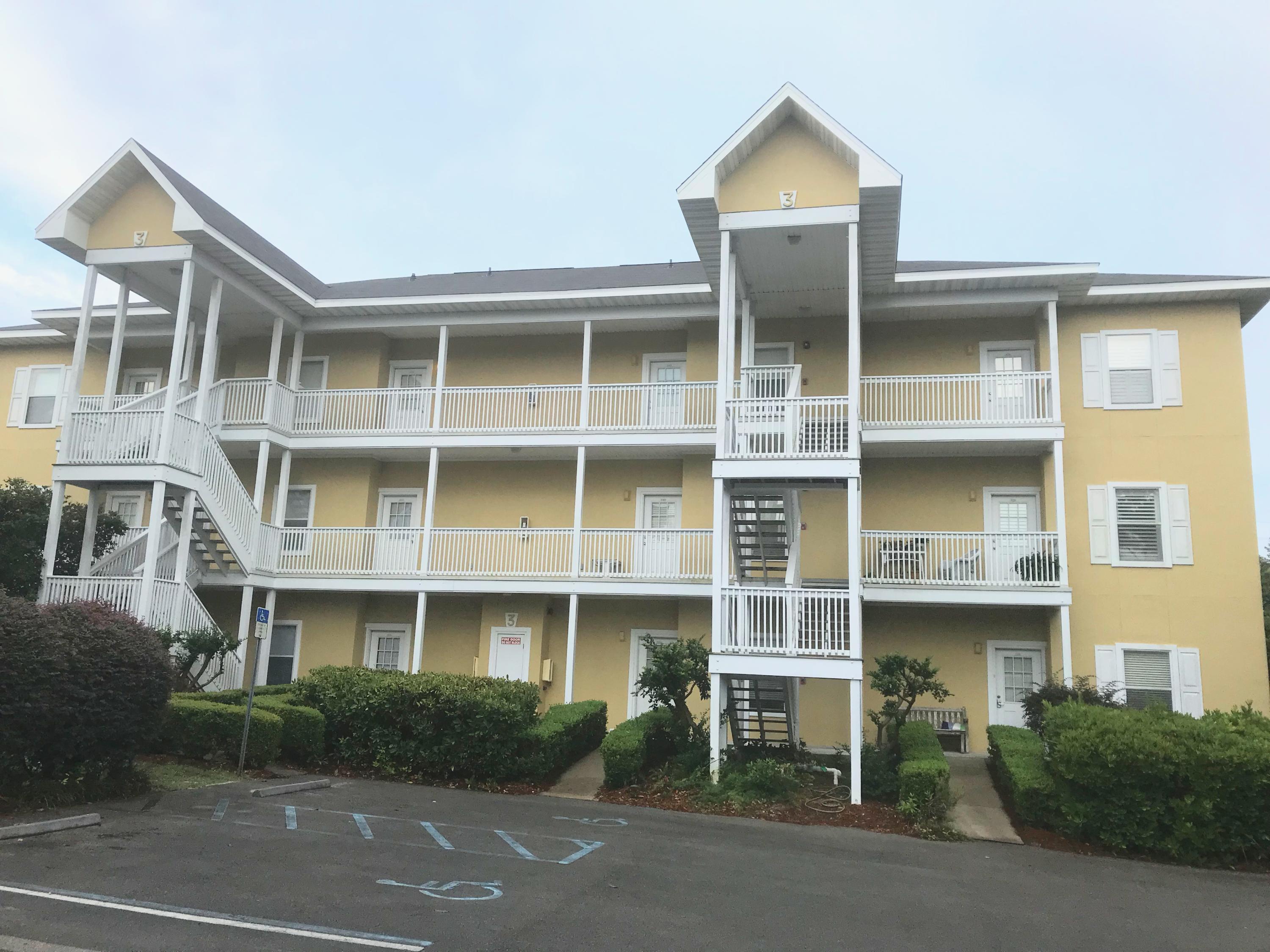 34 Heron's Watch Way, Unit 3203 Santa Rosa Beach, FL 32459 - Photo 1 of 12 a front view of a building with a yard and parking space
