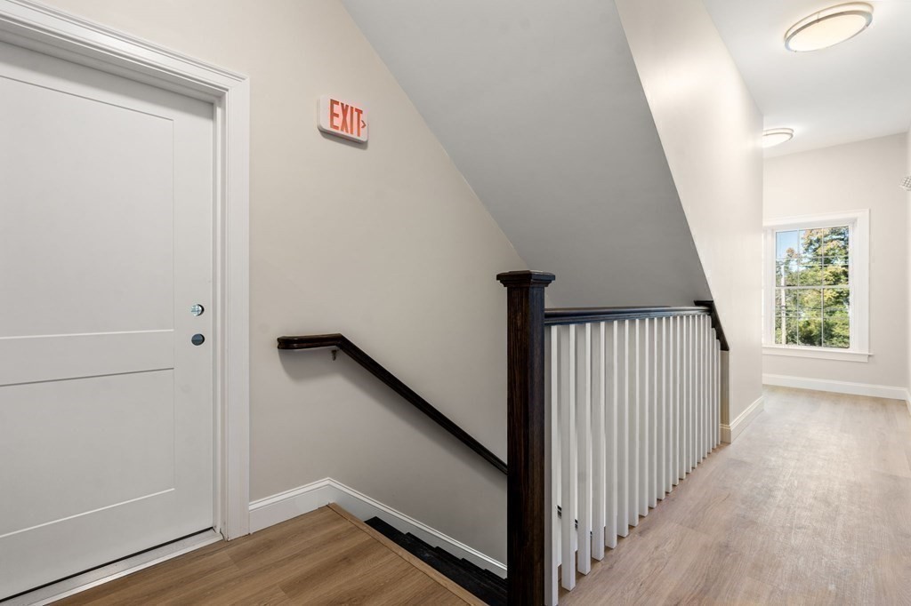 242 Main Street, Unit 203 Millis, MA 02054 - Photo 14 of 18 a view of a hallway with window and wooden floor