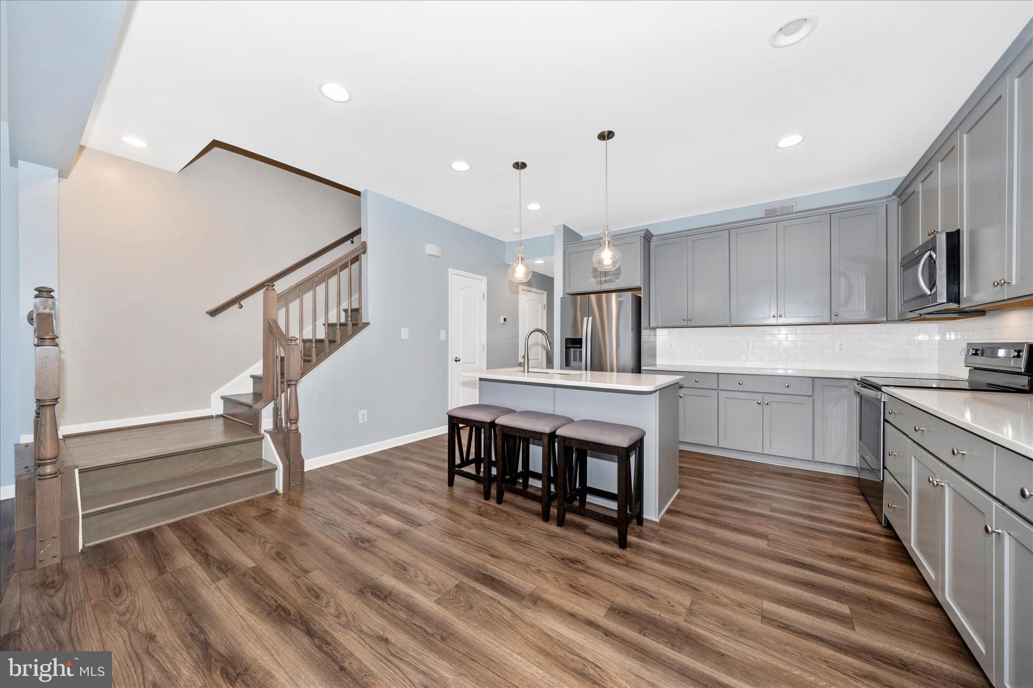 203 Charterhouse Street Falling Waters, WV 25419 - Photo 6 of 46 a kitchen with wooden floors and white cabinets