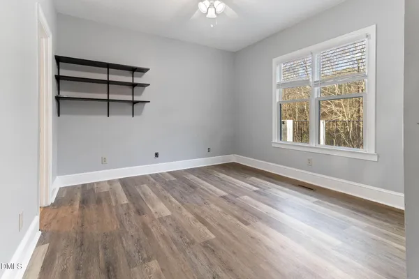 an empty room with wooden floor and a window
