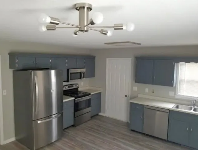 a kitchen with stainless steel appliances granite countertop a refrigerator and a sink