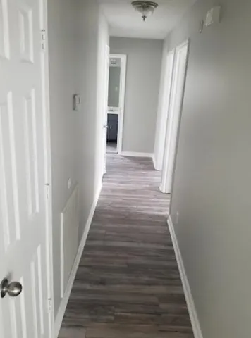 a view of a hallway with wooden floor and staircase