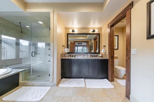 a bathroom with a glass door shower a sink and a mirror