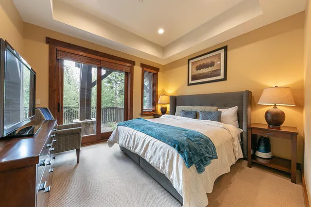 a bedroom with a bed and large windows