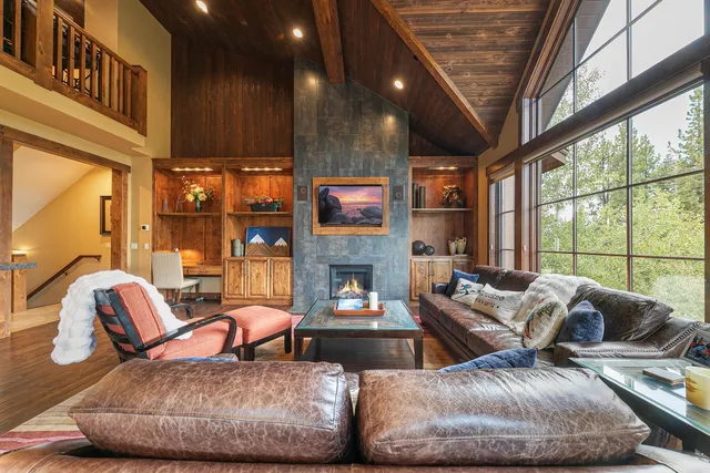 a living room with fireplace furniture and a large window