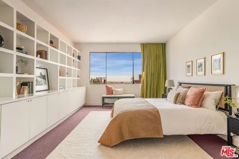 a bedroom with a large bed and a window