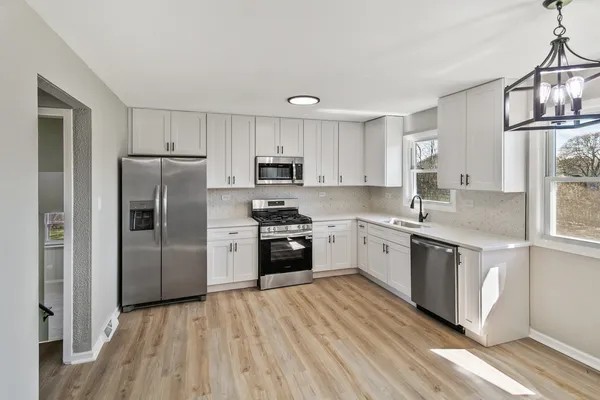 a kitchen with granite countertop a refrigerator stove top oven and sink