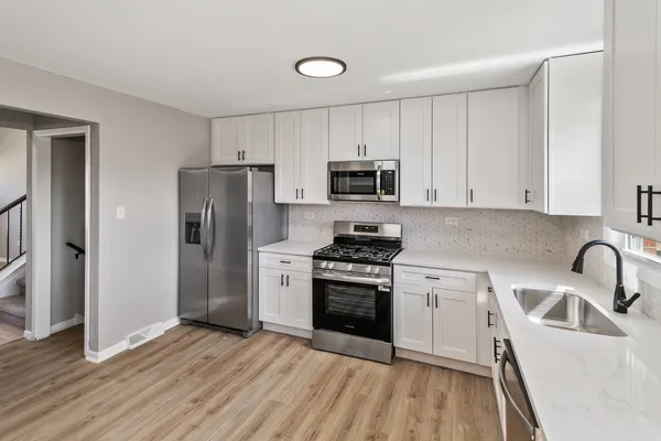 a kitchen with a sink a refrigerator and cabinets