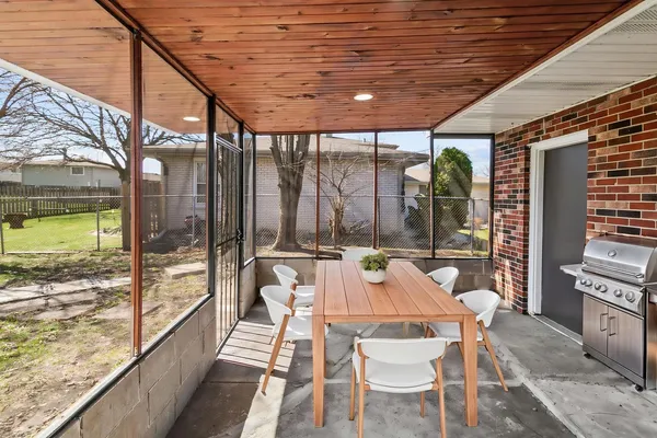 a view of a patio with table and chairs and wooden floor