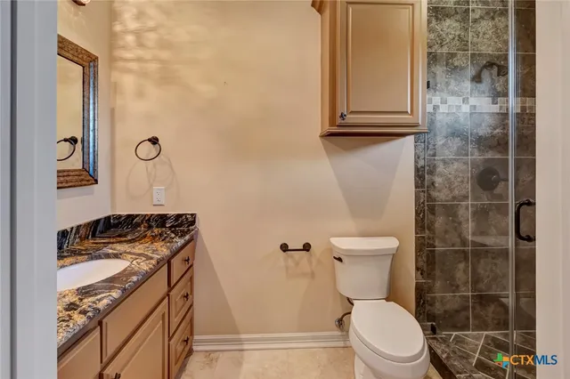 an empty room with wooden floor chandelier fan and windows