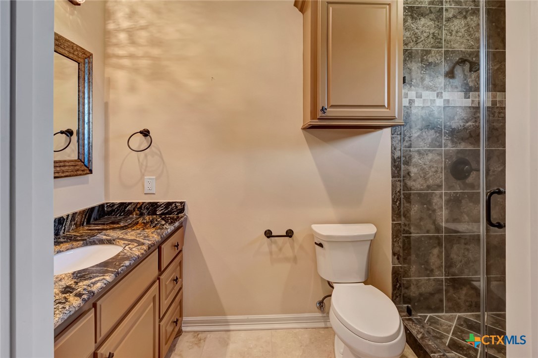 48 Post Oak Run Inez, TX 77968 - Photo 23 of 42 a bathroom with a granite countertop toilet a mirror and a shower