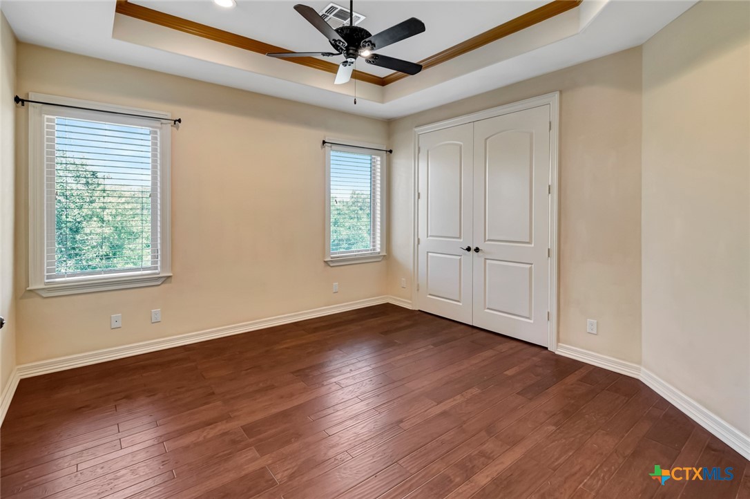 48 Post Oak Run Inez, TX 77968 - Photo 24 of 42 an empty room with wooden floor chandelier fan and windows