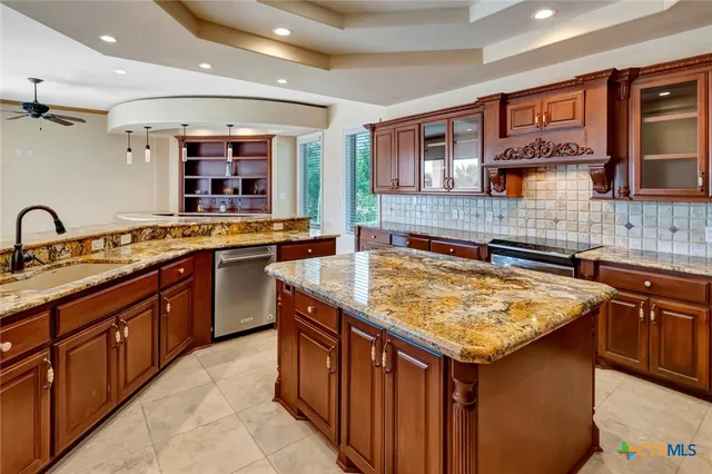 a kitchen with granite countertop sink and cabinets