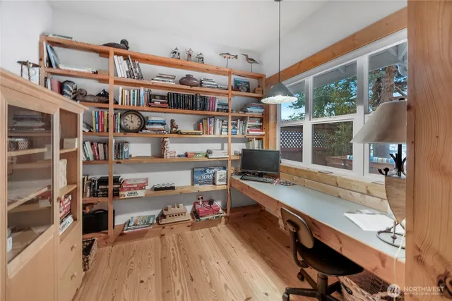a view of a workspace with furniture and a window
