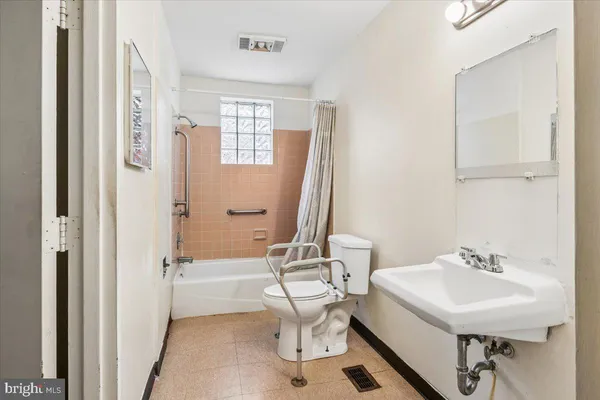 a bathroom with a sink a toilet and a mirror