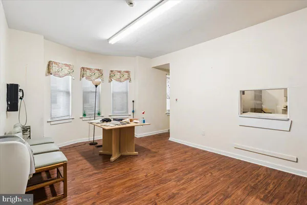 a view of a room with gym equipment and wooden floor