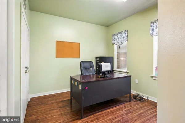 a view of a workspace with furniture and wooden floor
