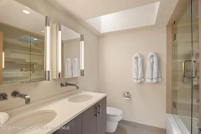 a bathroom with a sink and mirror with toilet