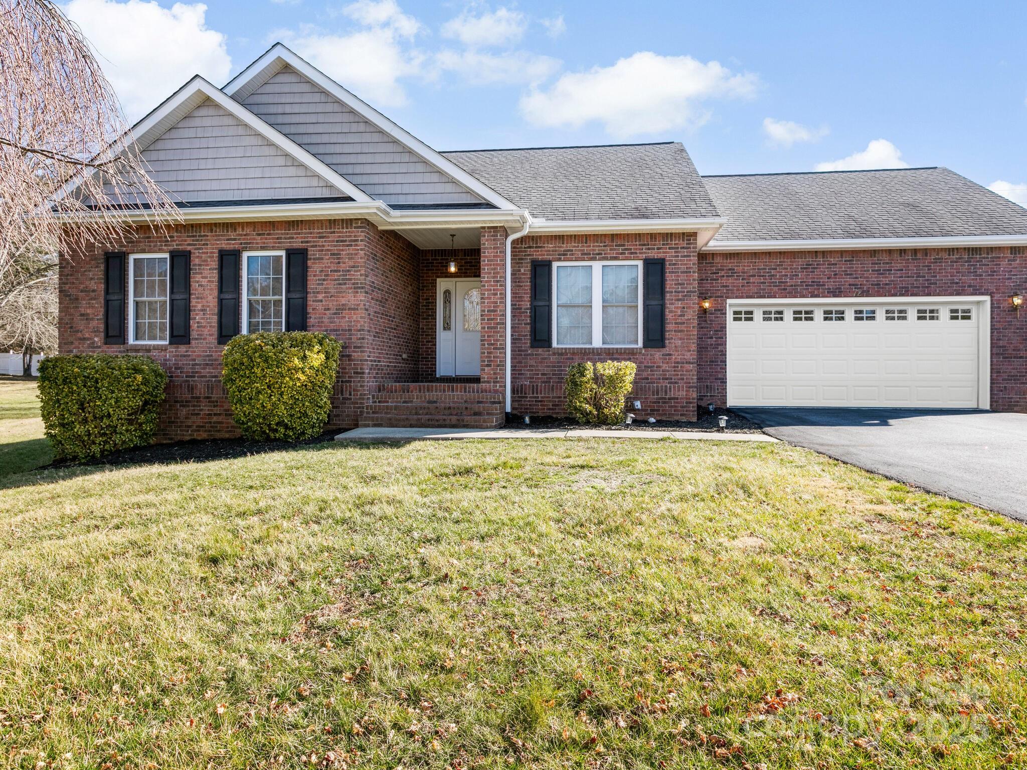 72 Classic Oaks Circle Hendersonville, NC 28792 - Photo 2 of 39 a front view of a house with a garden
