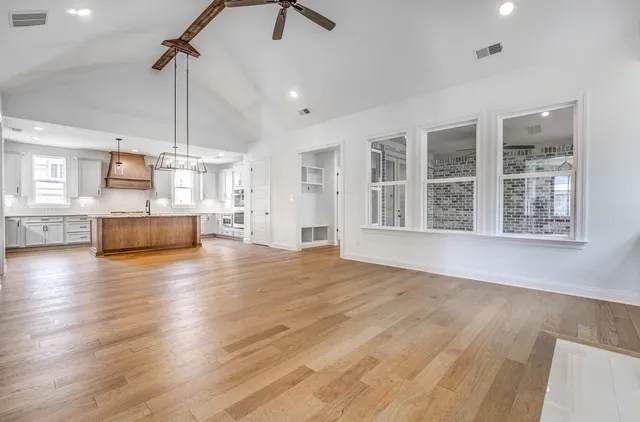 a view of a kitchen with stainless steel appliances wooden floor and a window