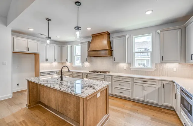 a kitchen with a stove a sink a center island and a window