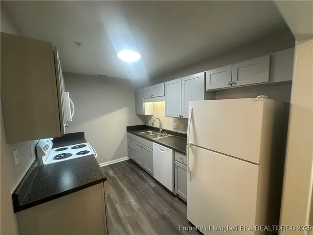 a kitchen with a refrigerator and a stove top oven