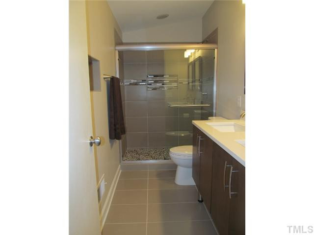 3444 Rugby Road Durham, NC 27707 - Photo 12 of 24 Master bath has walk-in shower with 12x24 tiles. There is a pebbled floor in shower that gives a foot massage while showering.