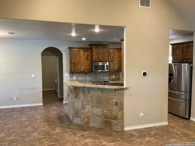 a kitchen with stainless steel appliances granite countertop a refrigerator and a sink