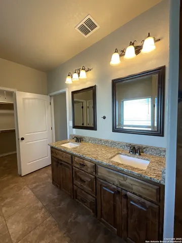a bathroom with a granite countertop sink a mirror and a shower
