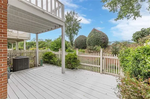 a view of a deck with a floor to ceiling window and wooden fence