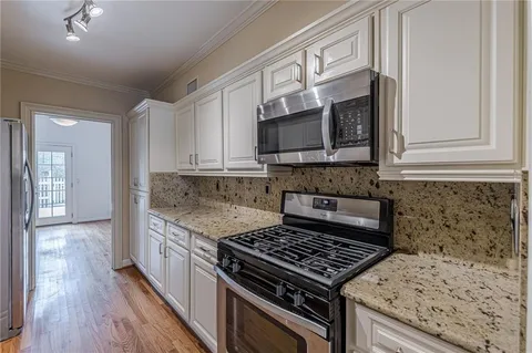 a kitchen with stainless steel appliances granite countertop a stove and a microwave