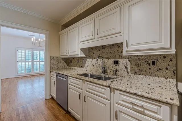 a kitchen with stainless steel appliances granite countertop a sink and dishwasher with wooden floor