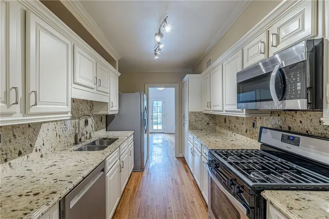 a kitchen with stainless steel appliances granite countertop a stove a sink dishwasher and a refrigerator